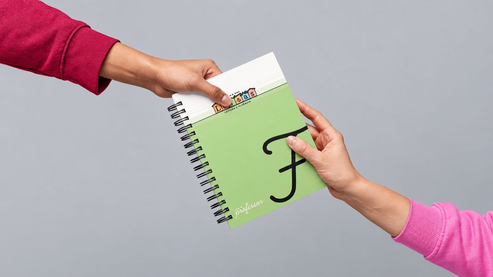 Livro do Educador sendo entregue de mãos em mãos